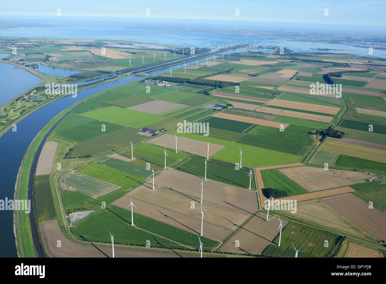 VISTA AEREA. Paesaggio di terreni agricoli e turbine eoliche, Scheldt orientale in lontananza. Regioni del Brabante del Nord e della Zelanda, Paesi Bassi. Foto Stock