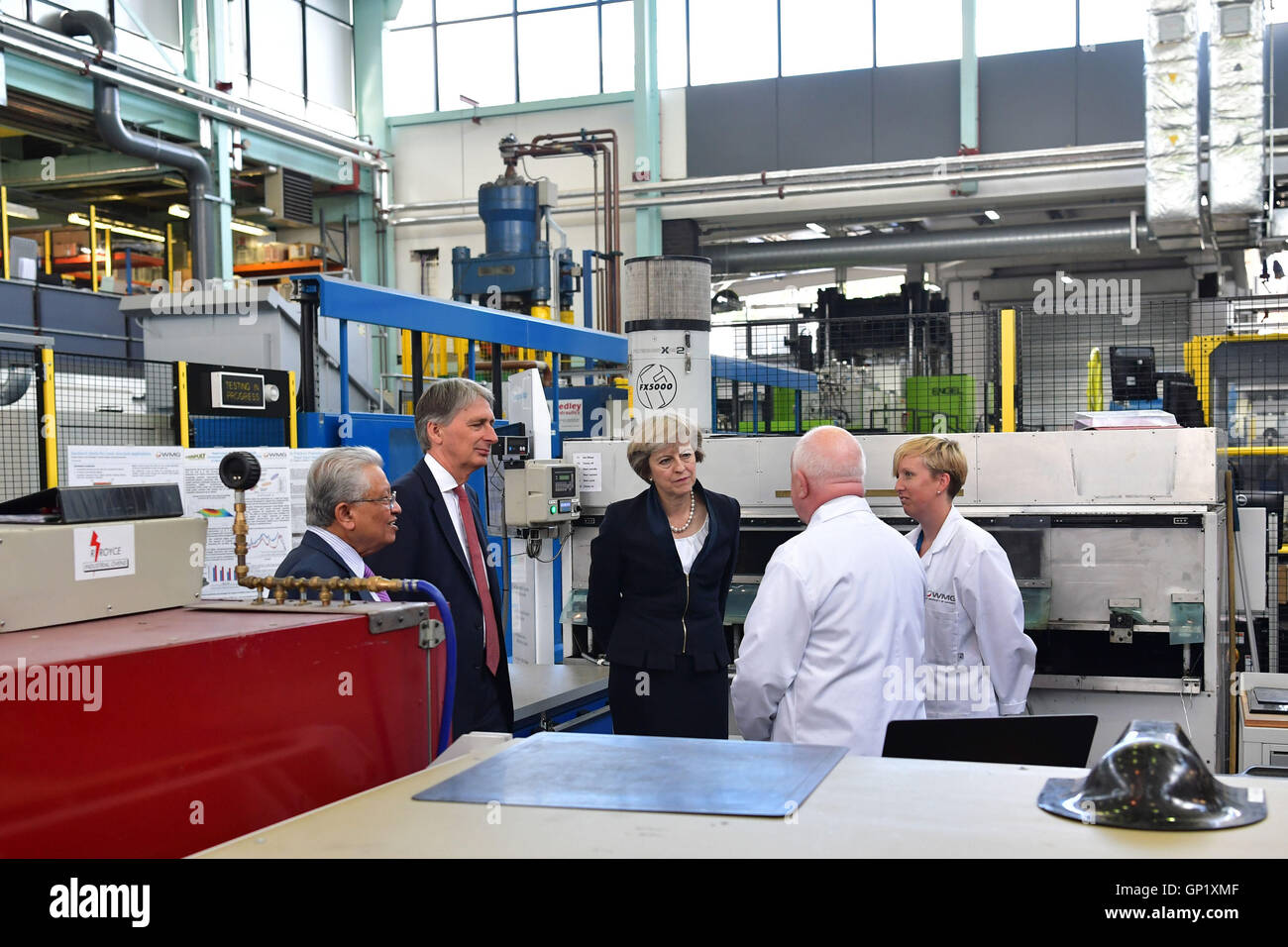 Il primo ministro Theresa Maggio con il Cancelliere dello Scacchiere, Philip Hammond soddisfare i tecnici durante una visita alla Jaguar Land Rover in fabbrica a Solihull dove ha utilizzato la visita per evidenziare che la Gran Bretagna continua a essere aperto per investimento economico a seguito del paese la decisione di lasciare l'Unione europea. Foto Stock