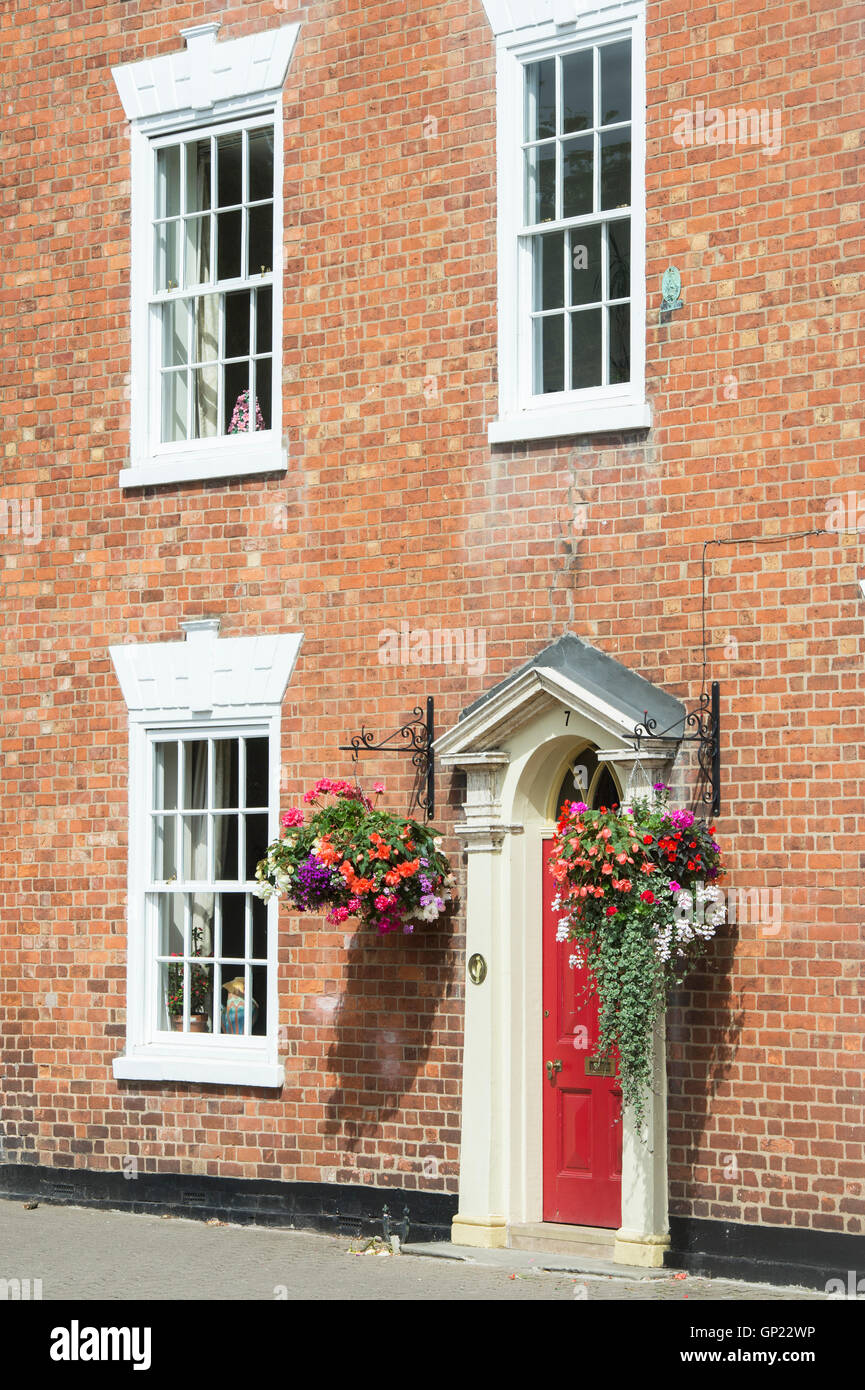 Cesti floreali pendenti sulla parte anteriore di una casa di città. Pershore, Worcestershire, Regno Unito Foto Stock