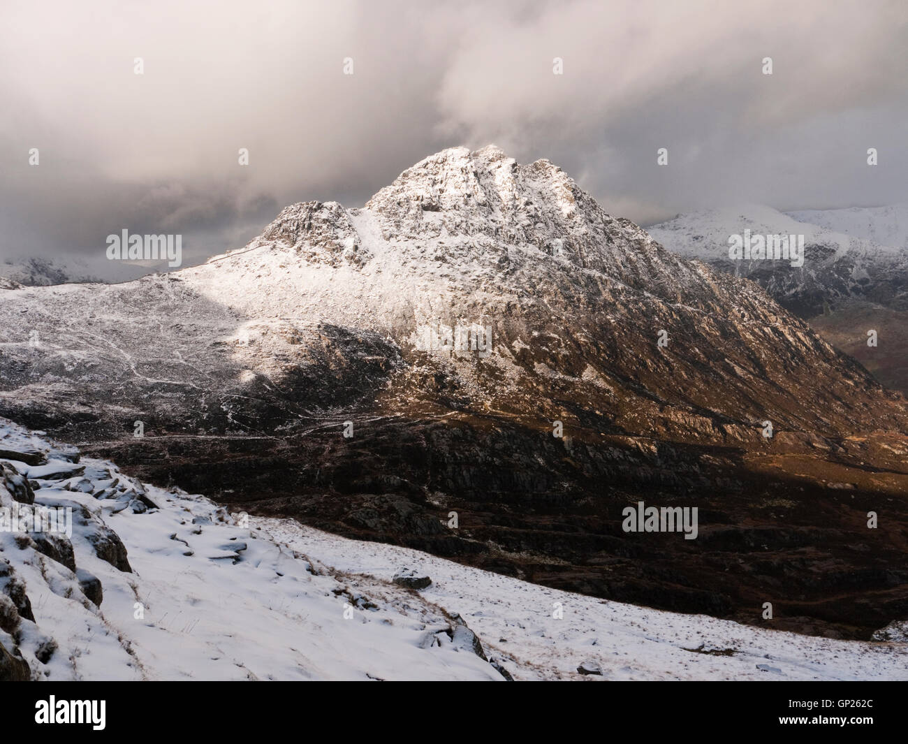 Il fronte orientale del famoso picco di Tryfan sotto una spolverata di neve, Ogwen Valley, il Parco Nazionale di Snowdonia Foto Stock