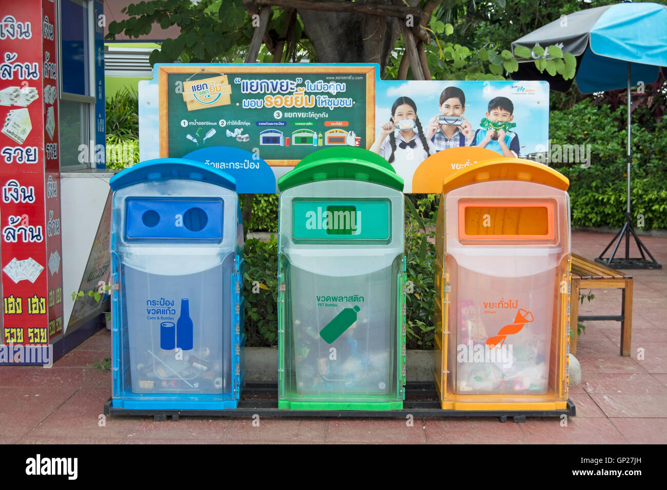 Con codifica a colori degli scomparti di riciclaggio in corrispondenza di un bordo strada area riposo in Thailandia, sud-est asiatico Foto Stock