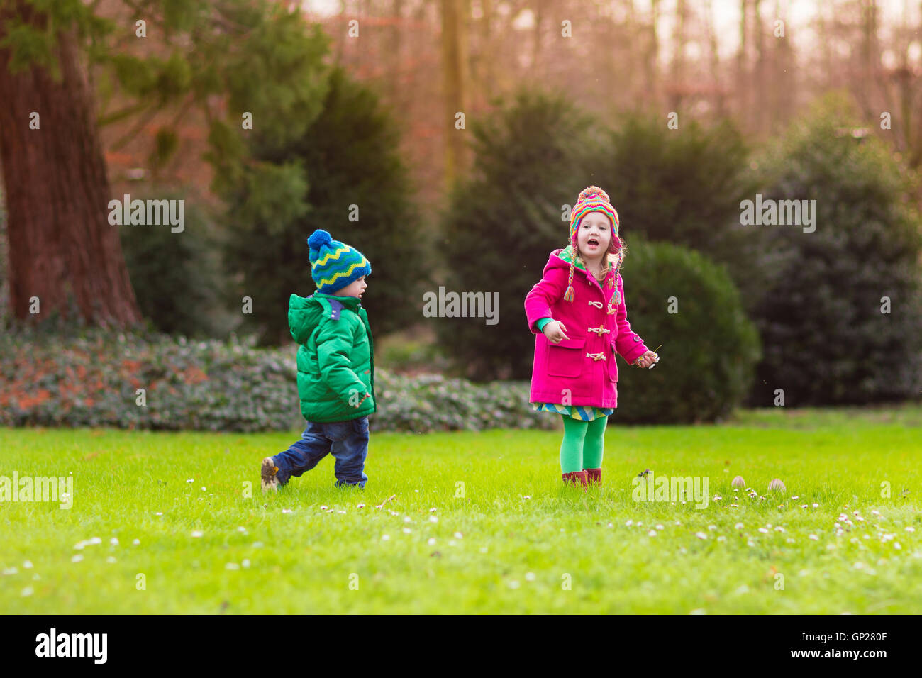Dei bambini felici giocando in autunno magnifico parco sulla soleggiata freddo giorno di caduta. Kids in giacche calde giocare con foglie d'oro. Foto Stock