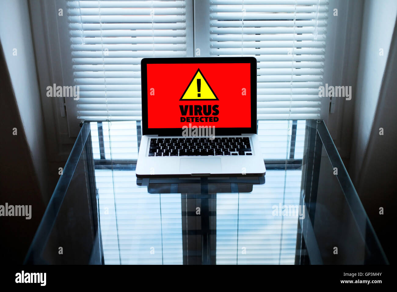 Virus informatici e simbolo di avvertimento sullo schermo del computer portatile in camera oscura Foto Stock