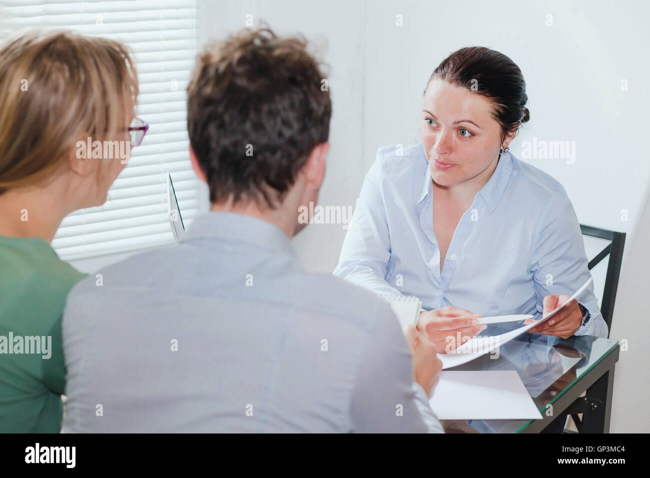 Consulente o agente immobiliare lavora con un paio di clienti in ufficio Foto Stock