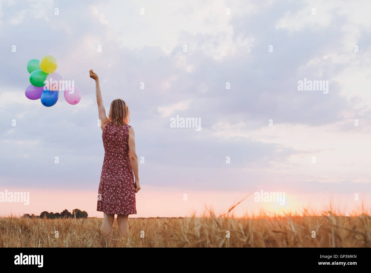 Il concetto di speranza, emozioni e sentimenti, donna con palloncini colorati nel campo, sfondo Foto Stock