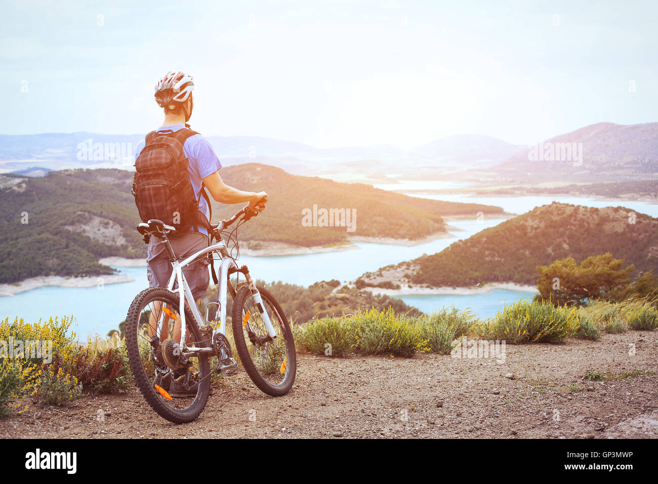Ciclismo e mountain bike, l'uomo con la bicicletta gode di vista panoramica al tramonto Foto Stock
