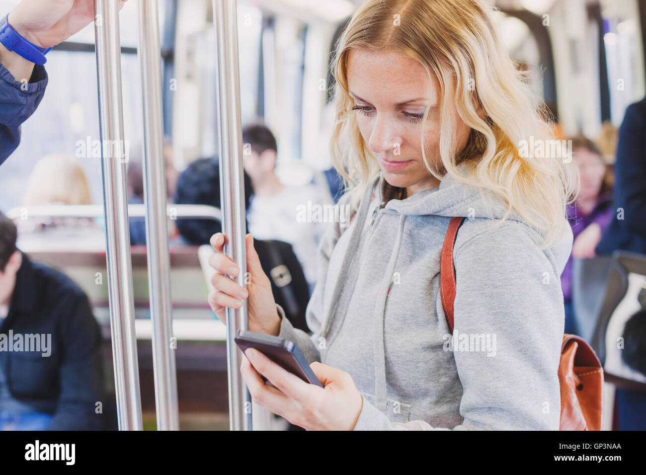 La gente in metro, pendolari, donna passeggero guardando lo schermo del suo smartphone Foto Stock