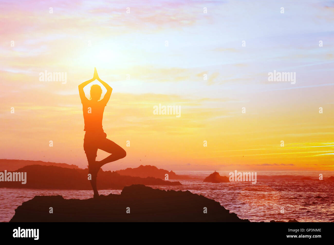 Bellissimo sfondo di yoga, silhouette di donna sulla spiaggia al tramonto, mindfulness Foto Stock