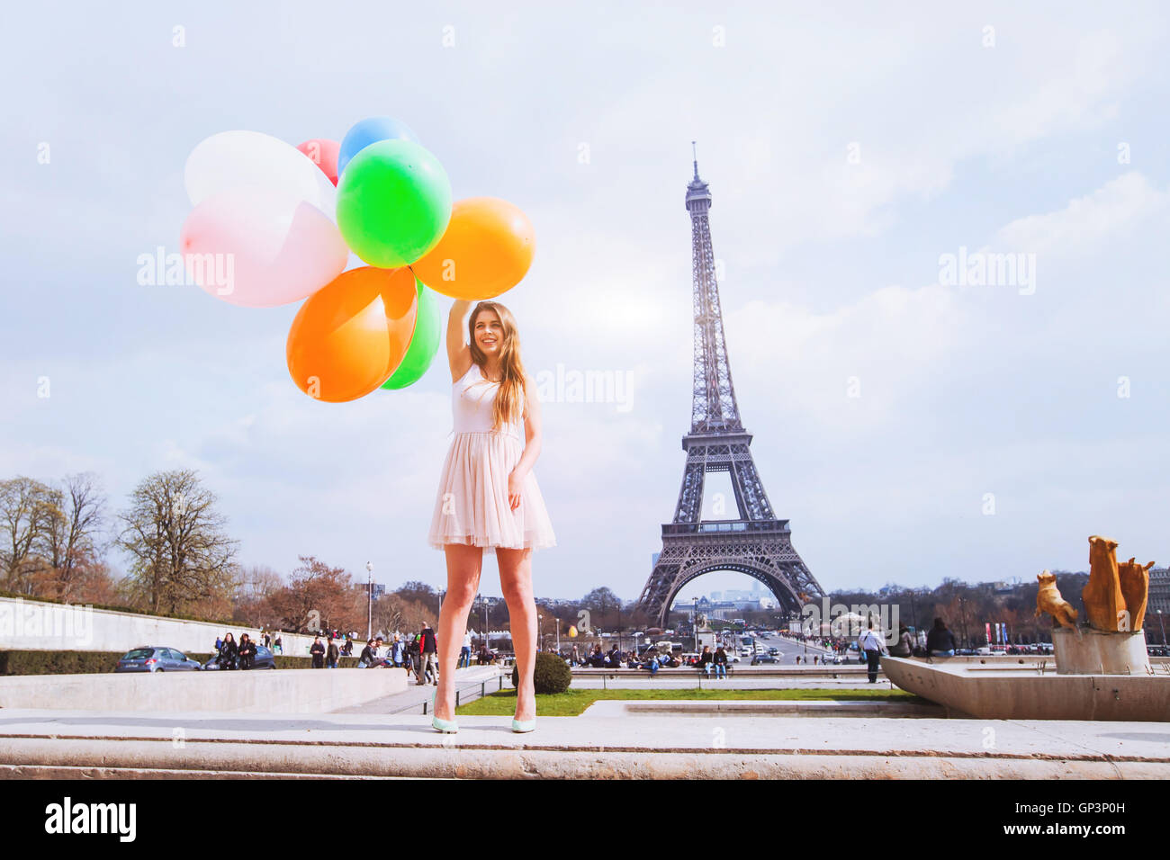 Felice ragazza con palloncini multicolori vicino alla Torre Eiffel a Parigi Foto Stock