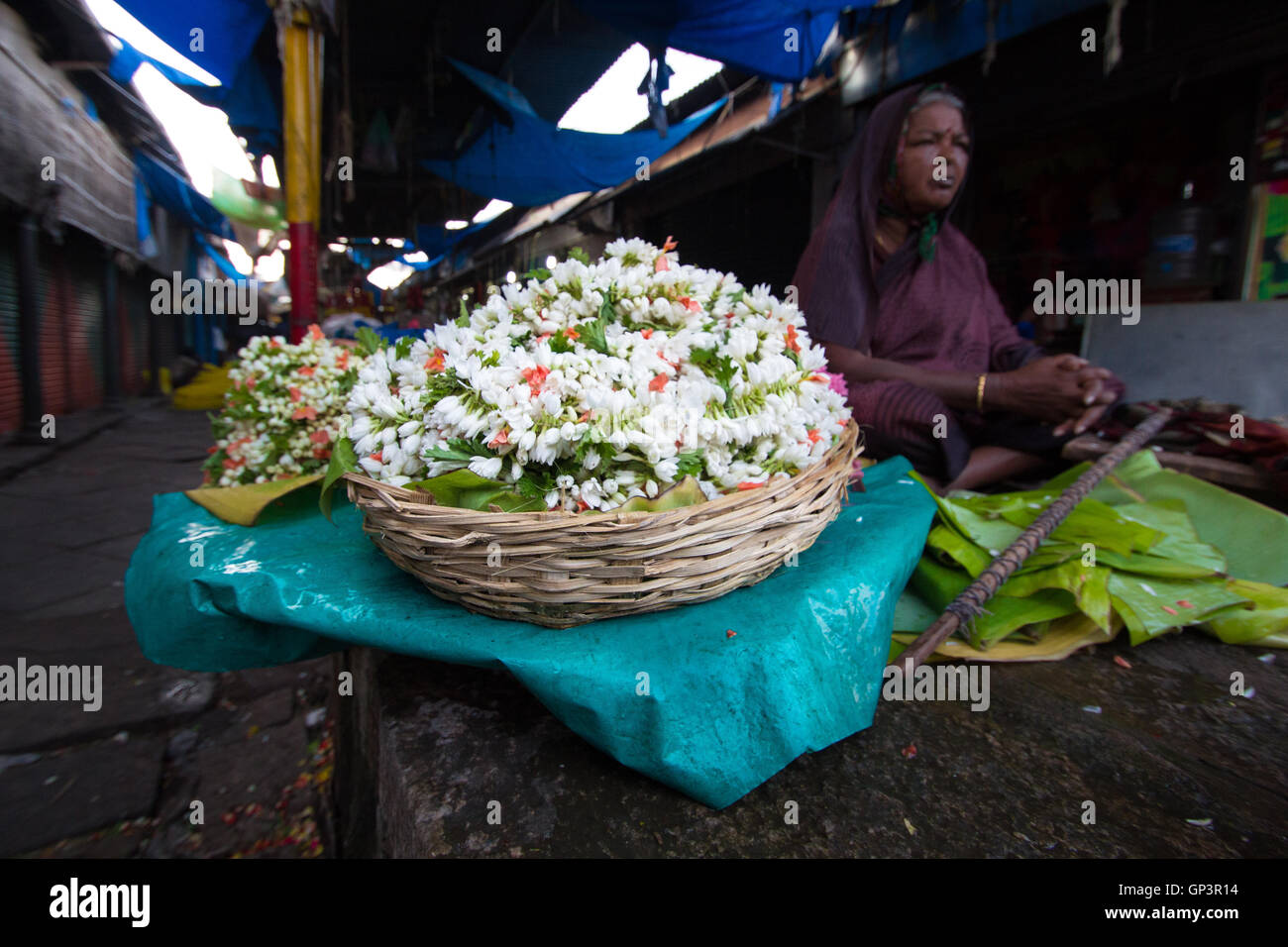 Persone che acquistano e vendono fiori e ghirlande presso il mercato dei fiori di Mysore, Karnataka, India. Foto Stock