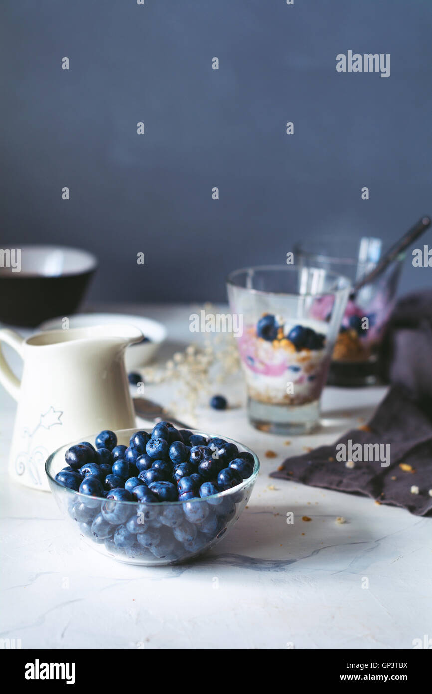 Sana parfait di colazione con muesli fatti in casa, yogurt e mirtilli su una tavola di marmo. Tonica immagine. Alimentare la vita ancora Foto Stock
