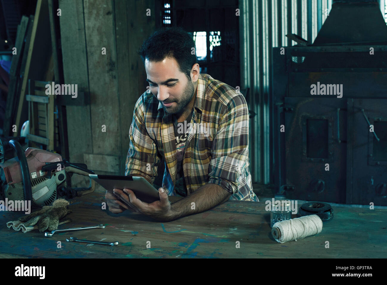 L uomo ricerca internet per le istruzioni di riparazione motosega rotto Foto Stock