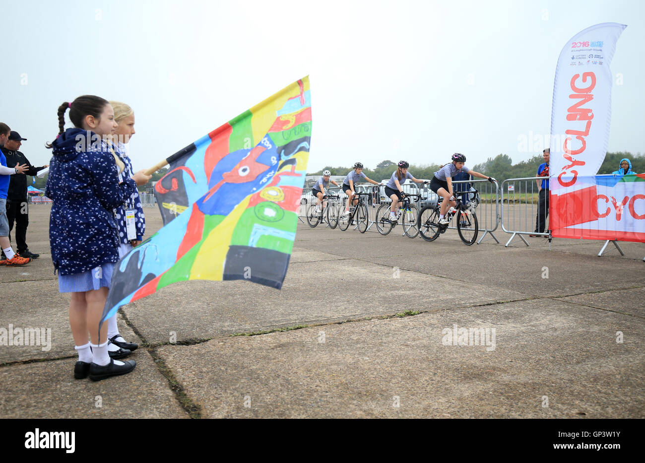 Flagbearers Sophie (sinistra) e Ruby da Burton sulla Scuola Wolds avviare i piloti del team crono ciclismo su strada il giorno due del 2016 Scuola di giochi a Prestwold Driving Center, Loughborough Foto Stock