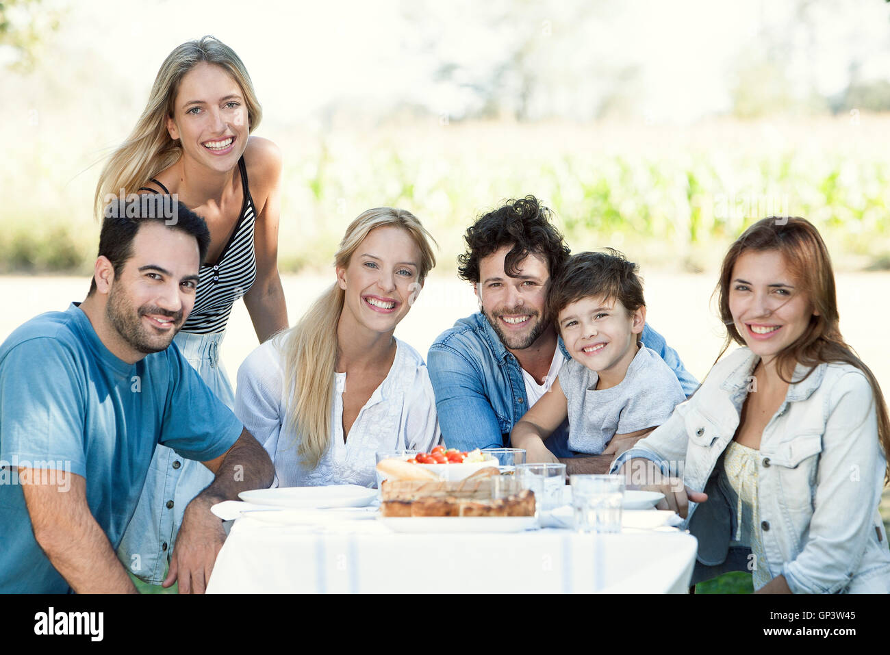 Famiglia avente picnic insieme all'aperto, ritratto di gruppo Foto Stock