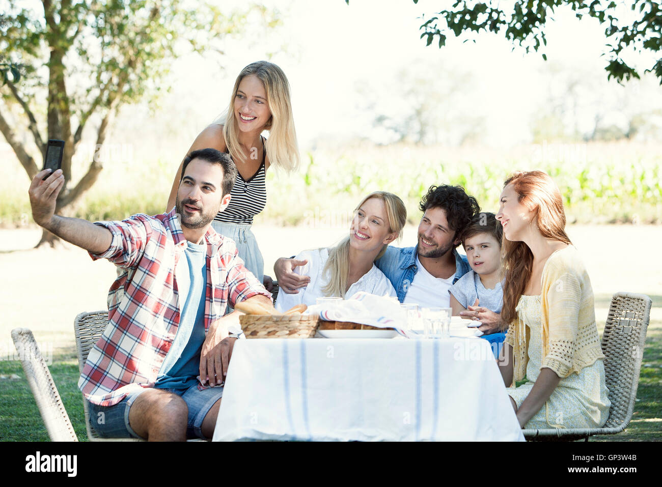 La famiglia in posa per una foto di gruppo mentre il pic-nic all'aperto Foto Stock