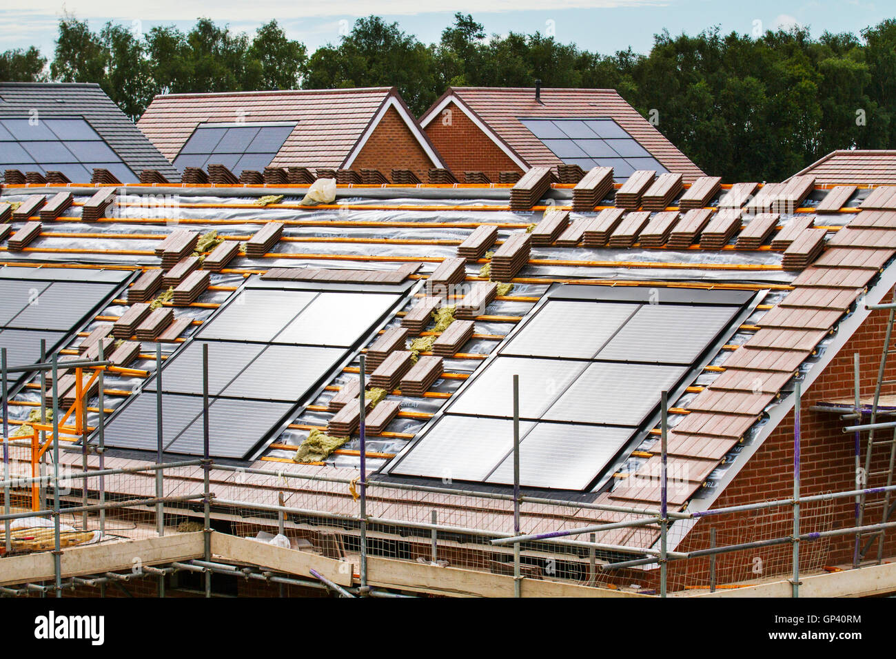 Redrow plc costruttori di case inglesi di proprietà; nuove case in costruzione, piccole case a efficienza energetica con tegole tetto pannelli solari integrati, o pannelli solari nel tetto su installazioni piastrellate casa in via di completamento, uno sviluppo a Buckshaw Village, vicino a Chorley, Lancashire, Regno Unito. Foto Stock