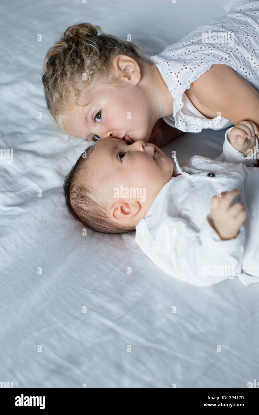 Bambina cuddling con baby fratello Foto Stock
