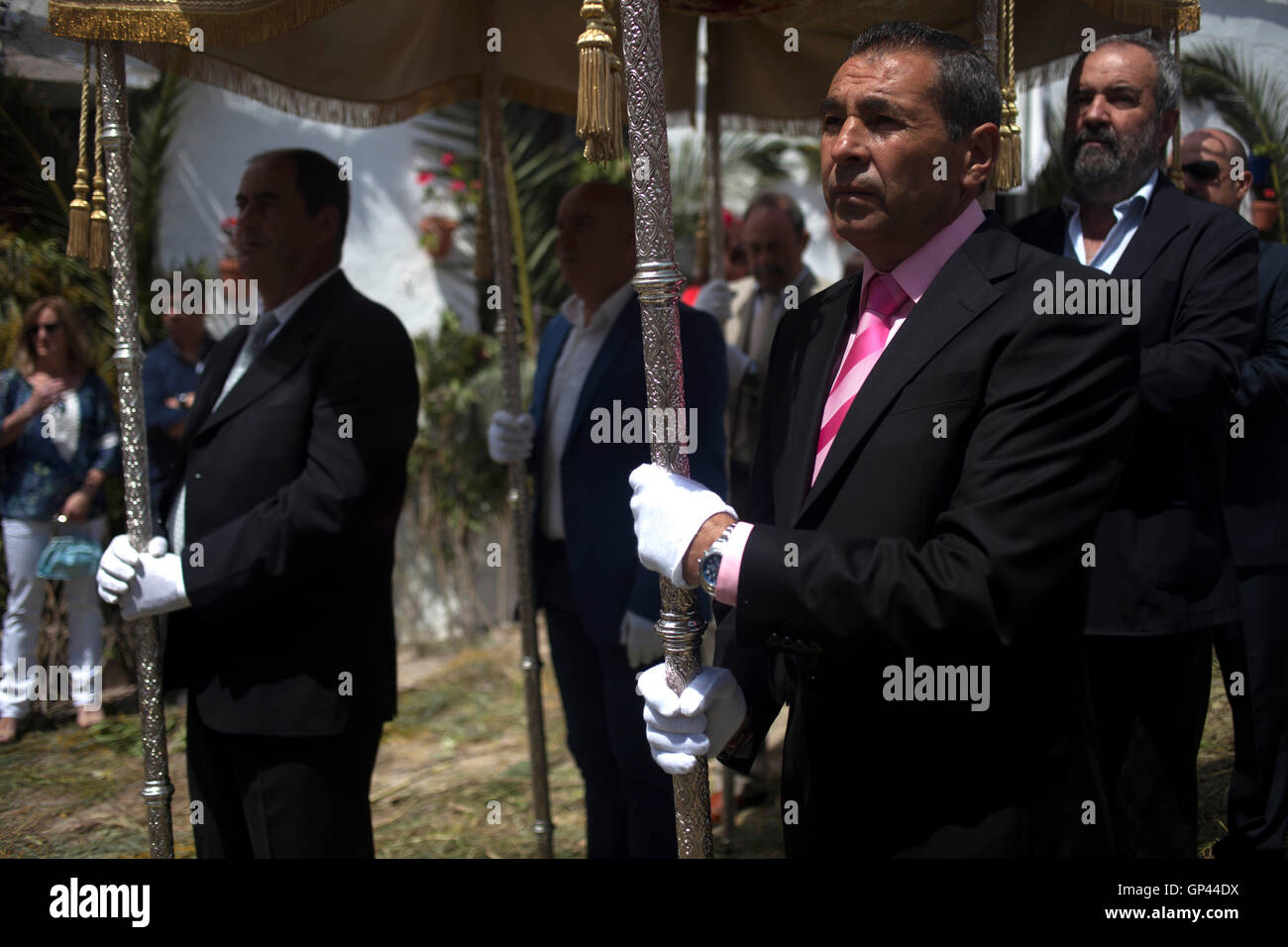 Gli uomini detengono un ombrellone durante il Corpus Domini celebrazione in El Gastor, Sierra de Cadice, Andalusia, Spagna Foto Stock