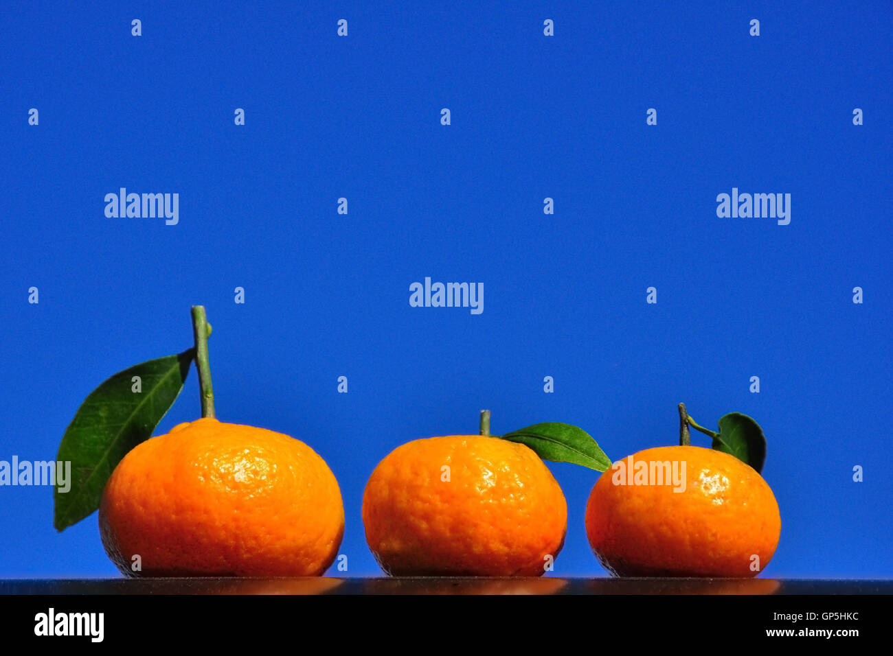 Tre arance con foglie Foto Stock