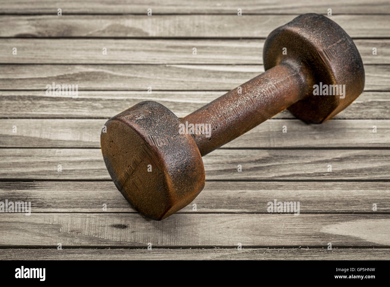 Vintage di ferro arrugginiti dumbbell su tavole di legno di sfondo - Concetto di fitness Foto Stock