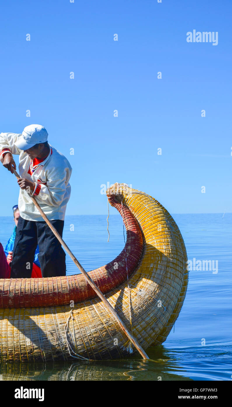 Non identificato uomo nativo in una tradizionale barca sul lago Titicaca Foto Stock