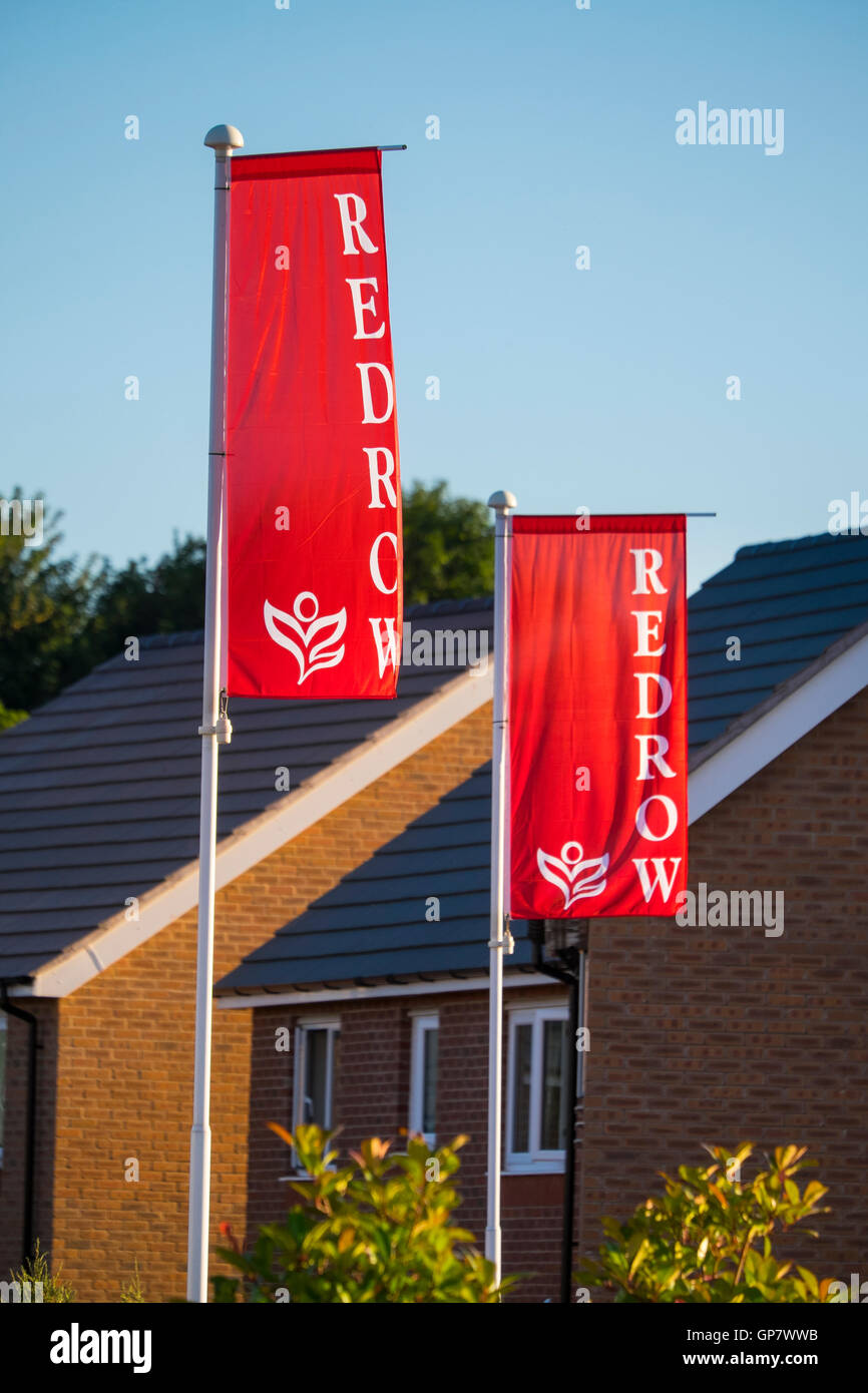 Redrow costruttori bandiere al di fuori di un alloggiamento dello sviluppo in Shifnal, Shropshire, Inghilterra, Regno Unito Foto Stock