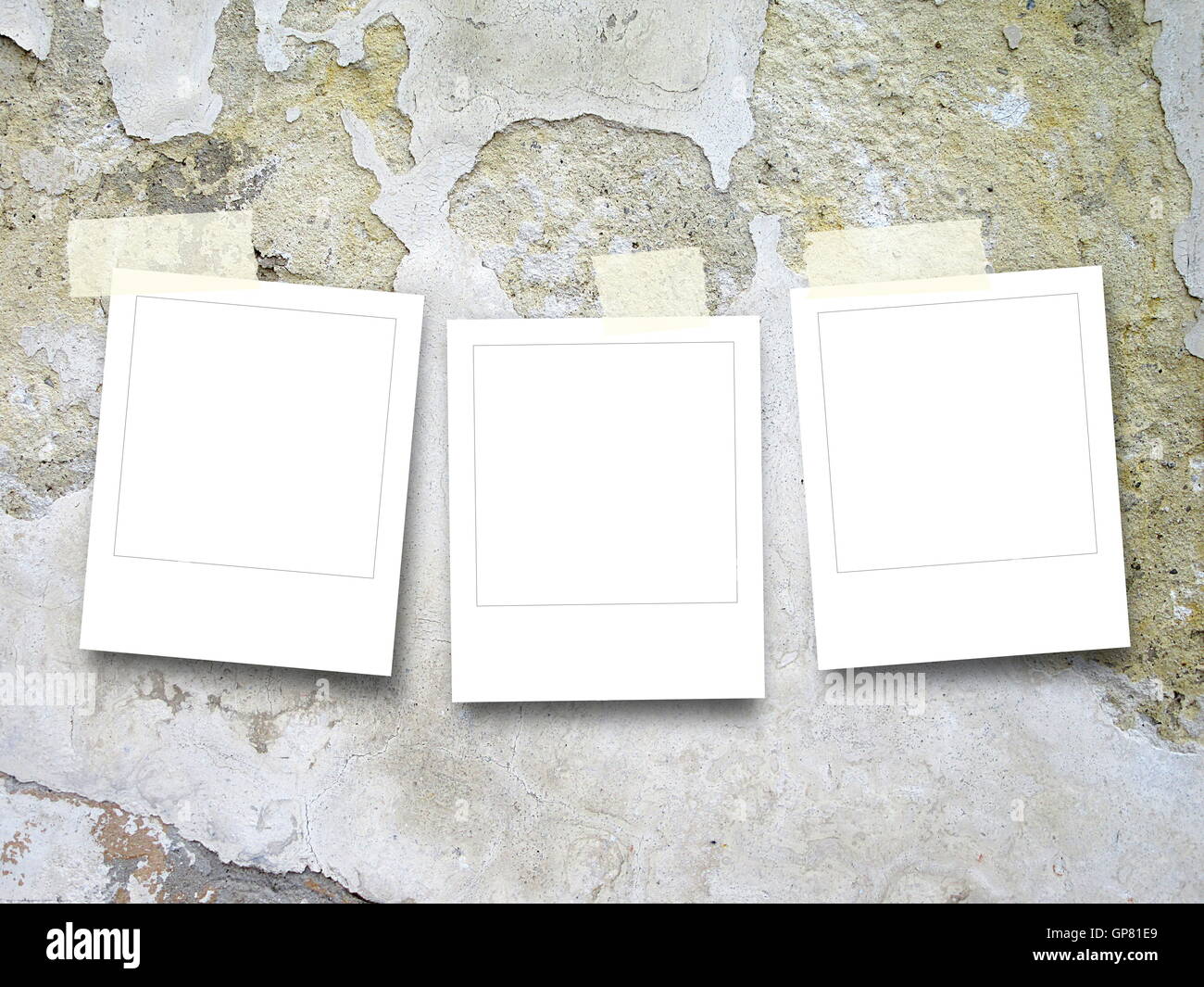 Close-up di tre quadrato bianco instant photo frame con nastro adesivo sul graffiato e screpolata muro di cemento sullo sfondo Foto Stock