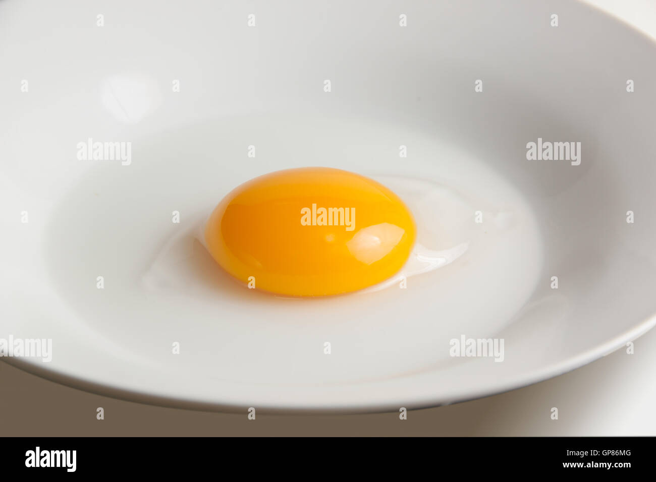 Materie duck tuorlo d'uovo sul piatto bianco sul tavolo Foto Stock