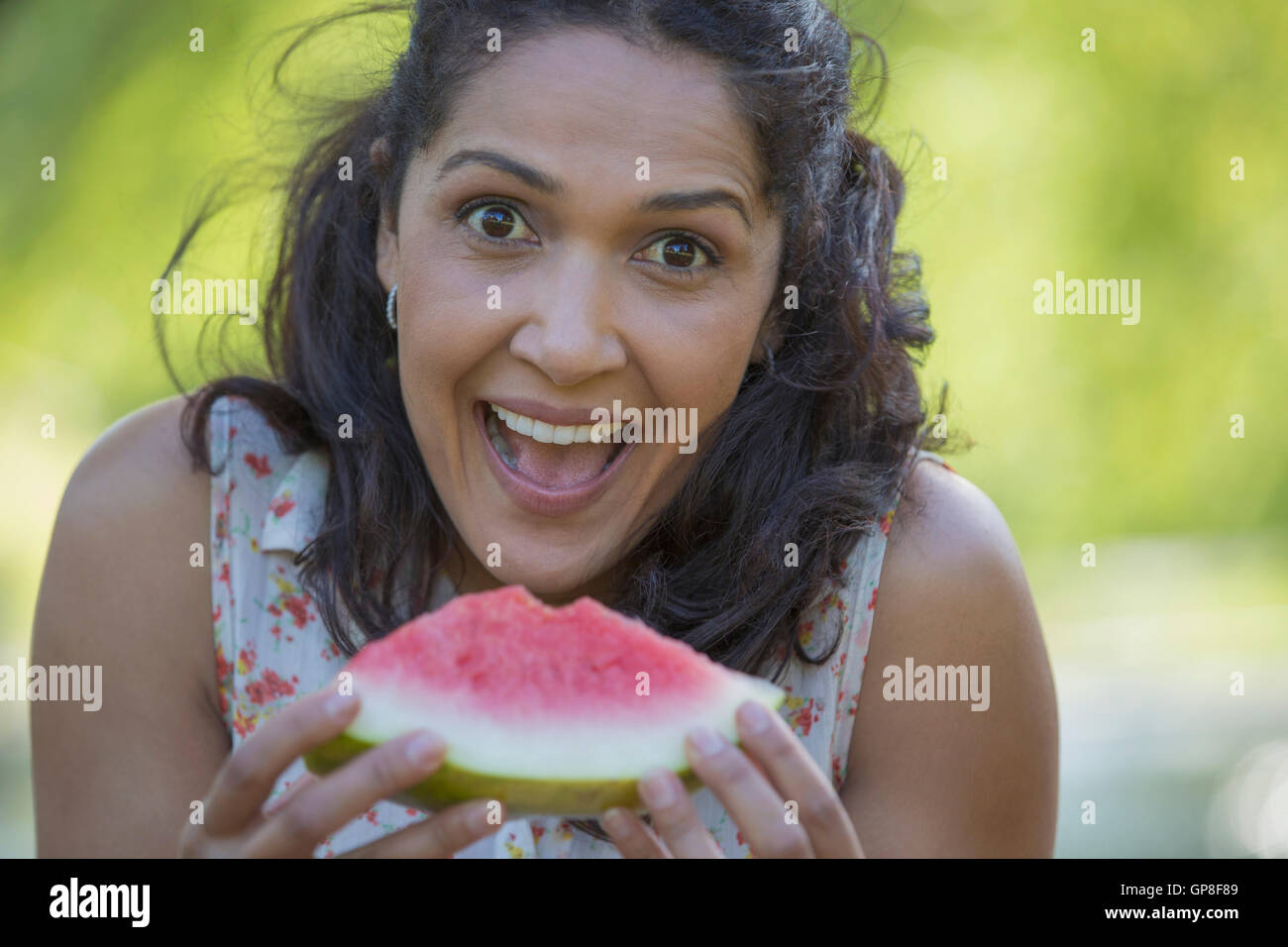 Ritratto di felice donna ispanica mangiando anguria Foto Stock