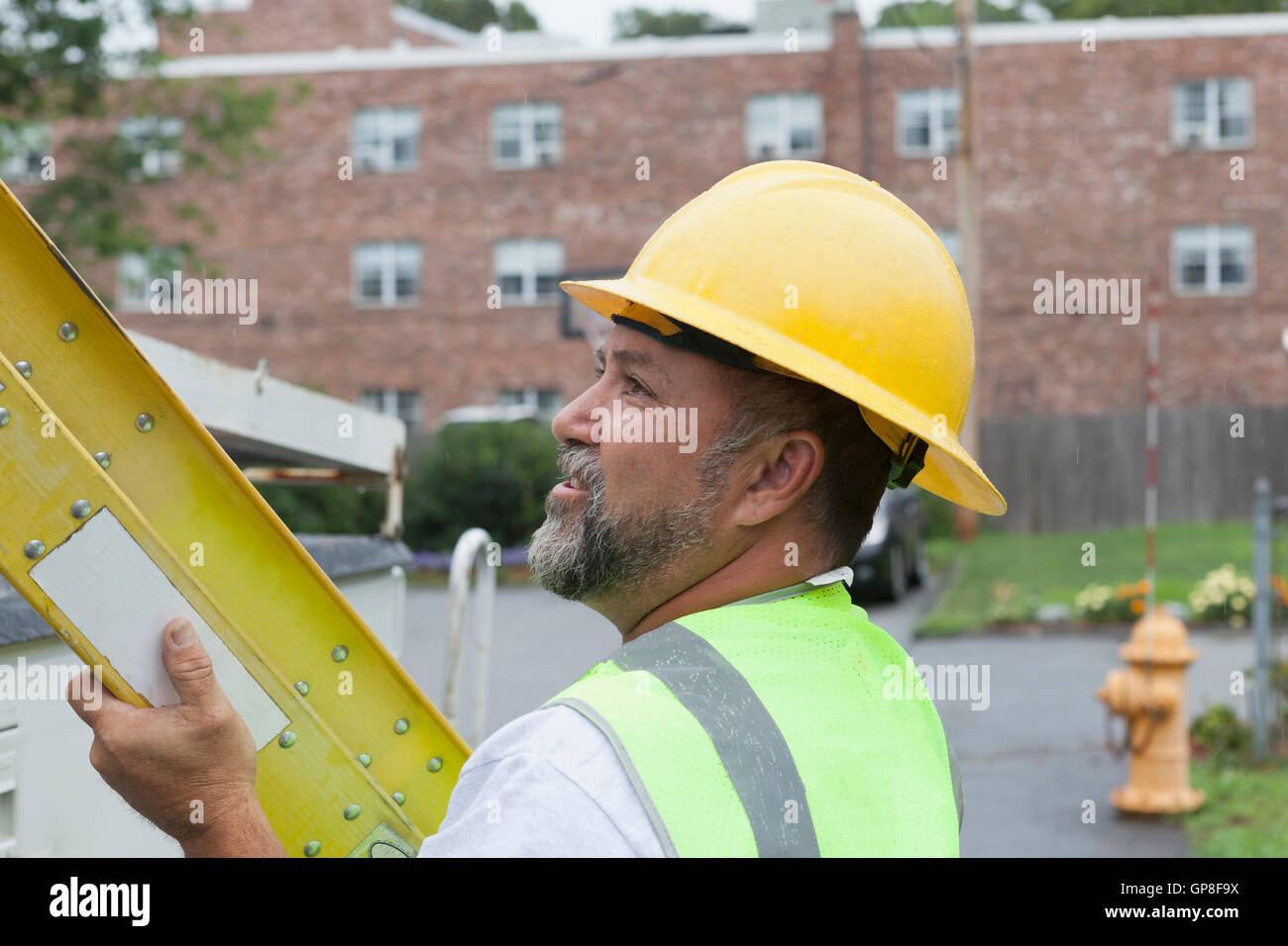 Lavoratore di utilità preparare una scaletta per il lavoro presso il sito Foto Stock