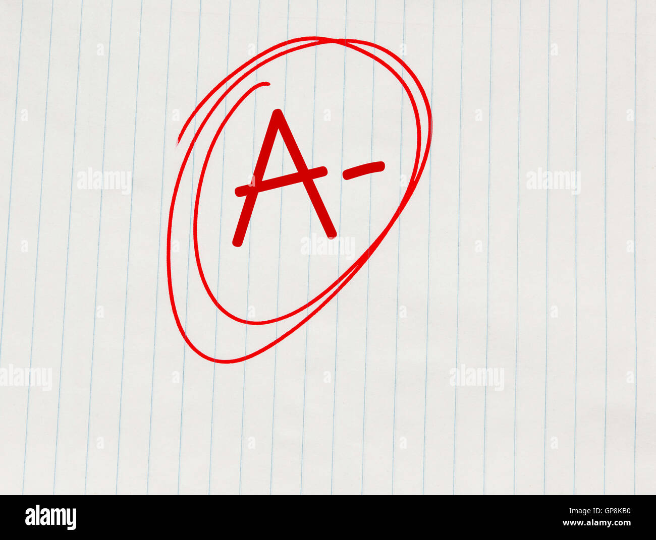 A minus (A-) grade written in red on notebook paper Foto Stock
