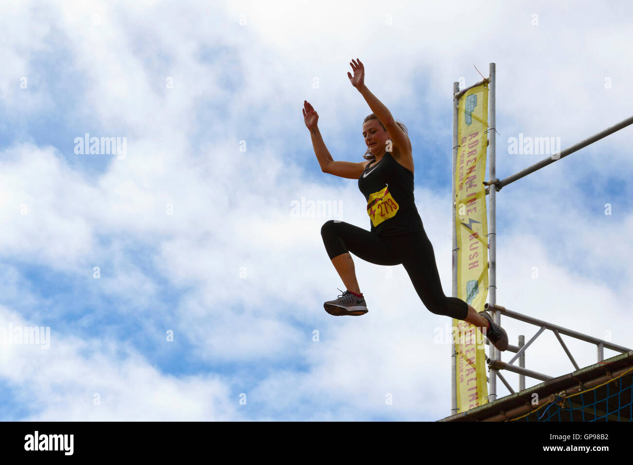 Persona di saltare fuori di un 5m alta piattaforma e a un airbag come parte dell'adrenalina pura razza (per Macmillan), Bristol, 2016. Foto Stock