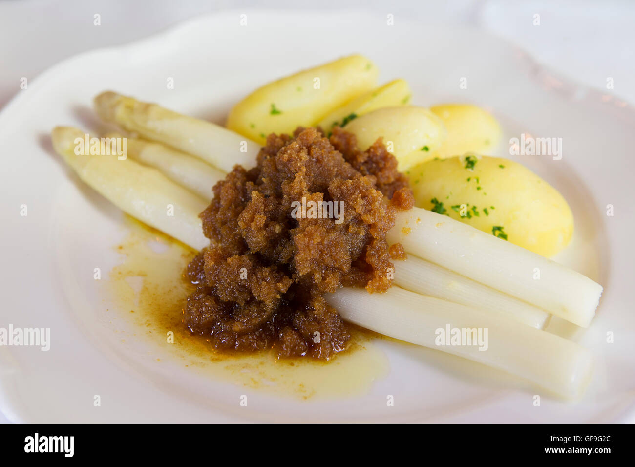 Asparagi bianchi è servito con patate lesse e mollica di pane imburrato in di Dresda, Germania. Foto Stock