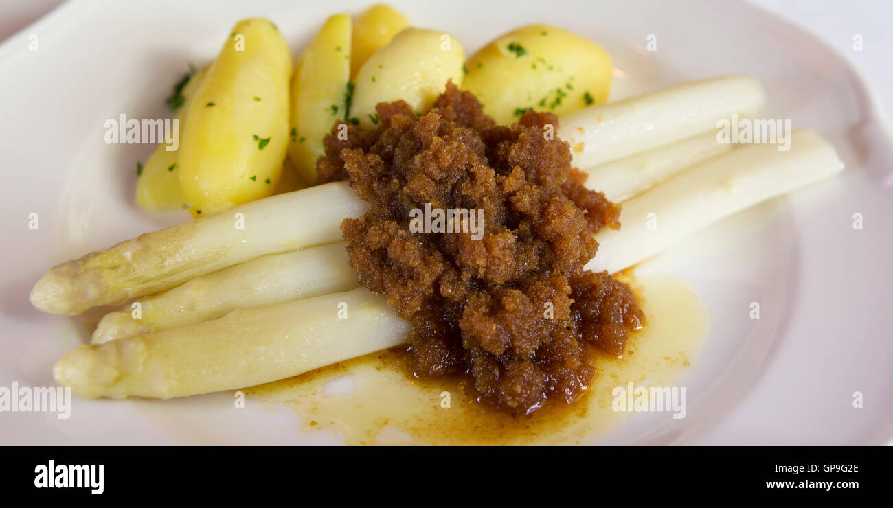 Asparagi bianchi è servito con patate lesse e mollica di pane imburrato in di Dresda, Germania. Foto Stock