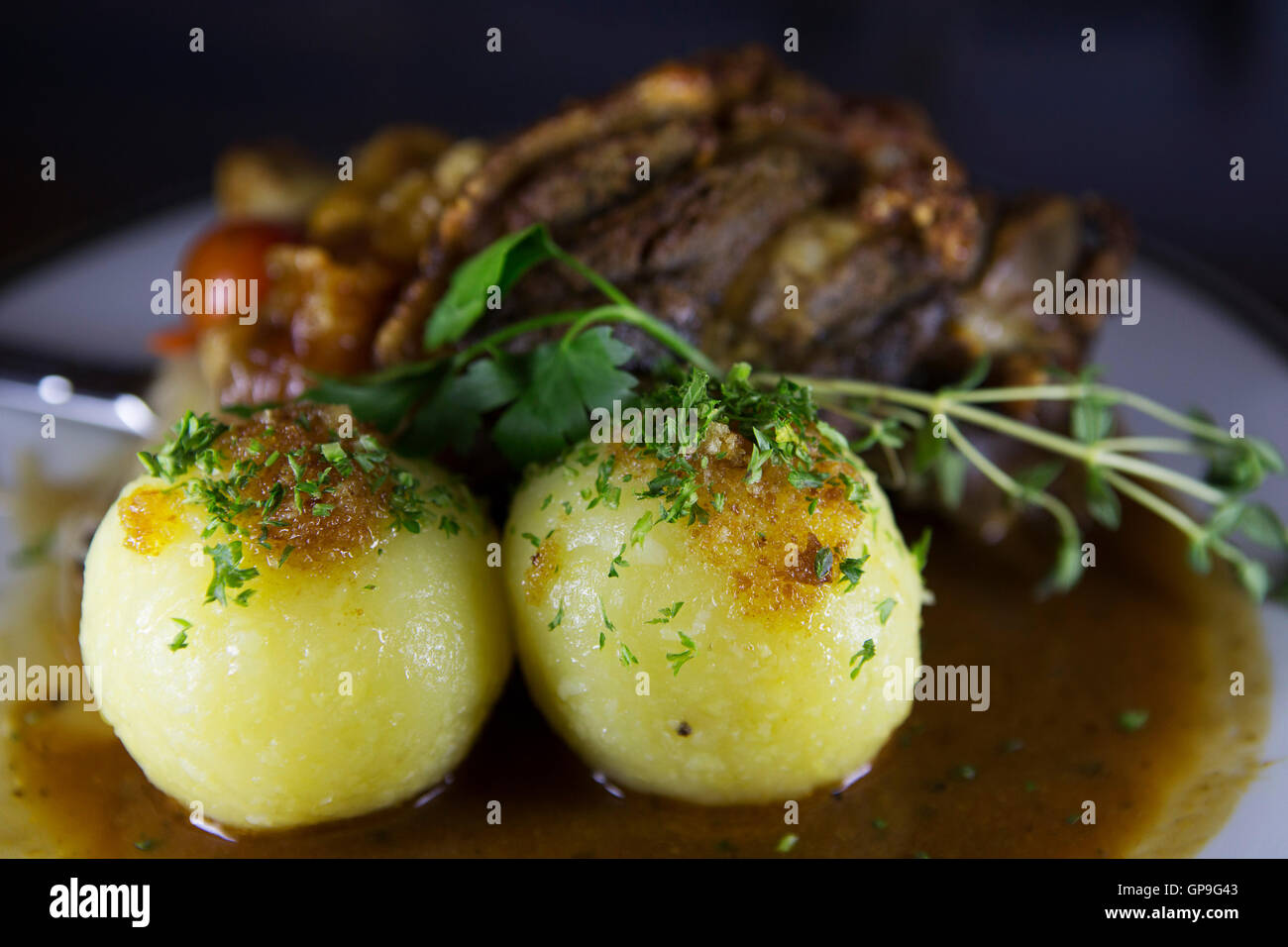 Un Schweinshax (maiale fuso a snodo) servita con gnocchetti di patate di Dresda, in Germania. Foto Stock