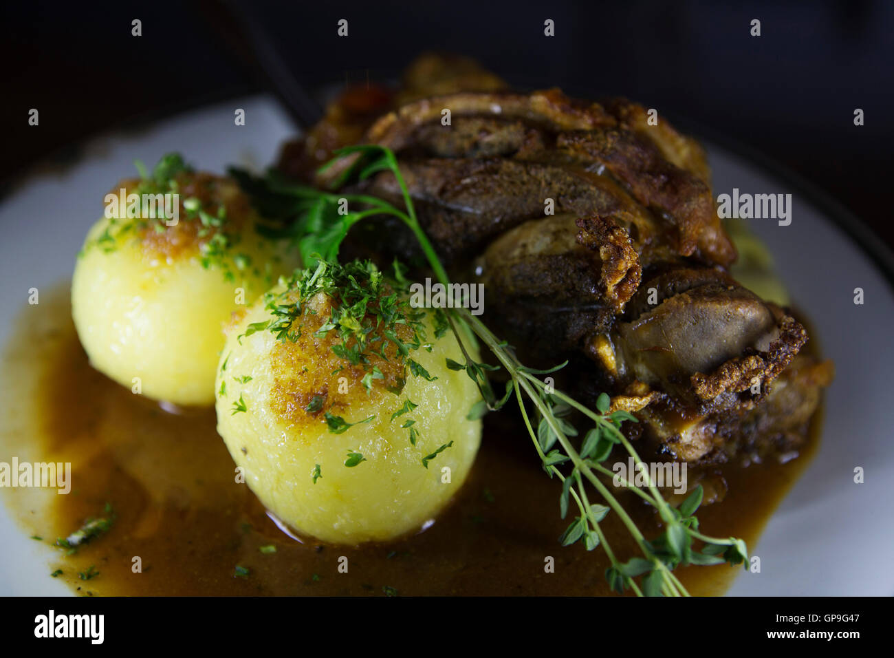 Un Schweinshax (maiale fuso a snodo) servita con gnocchetti di patate di Dresda, in Germania. Foto Stock