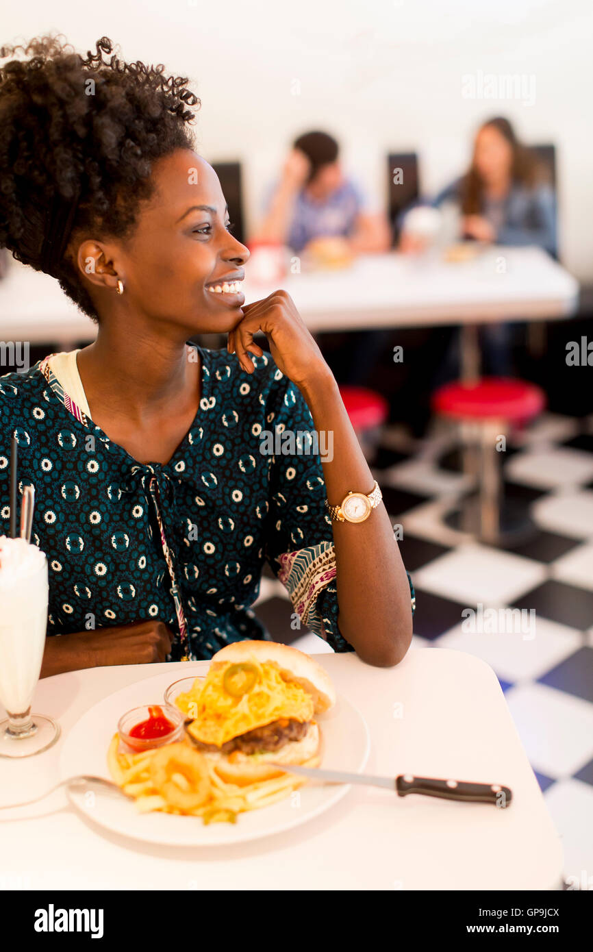 Giovane africano donna americana nel diner Foto Stock