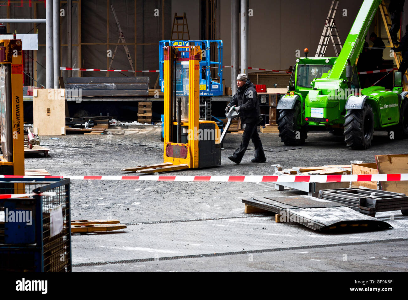 Un uomo al lavoro su un pre-Berlinale sito in costruzione al di fuori della Potsdamer Platz Theater di Berlino, Germania. Foto Stock