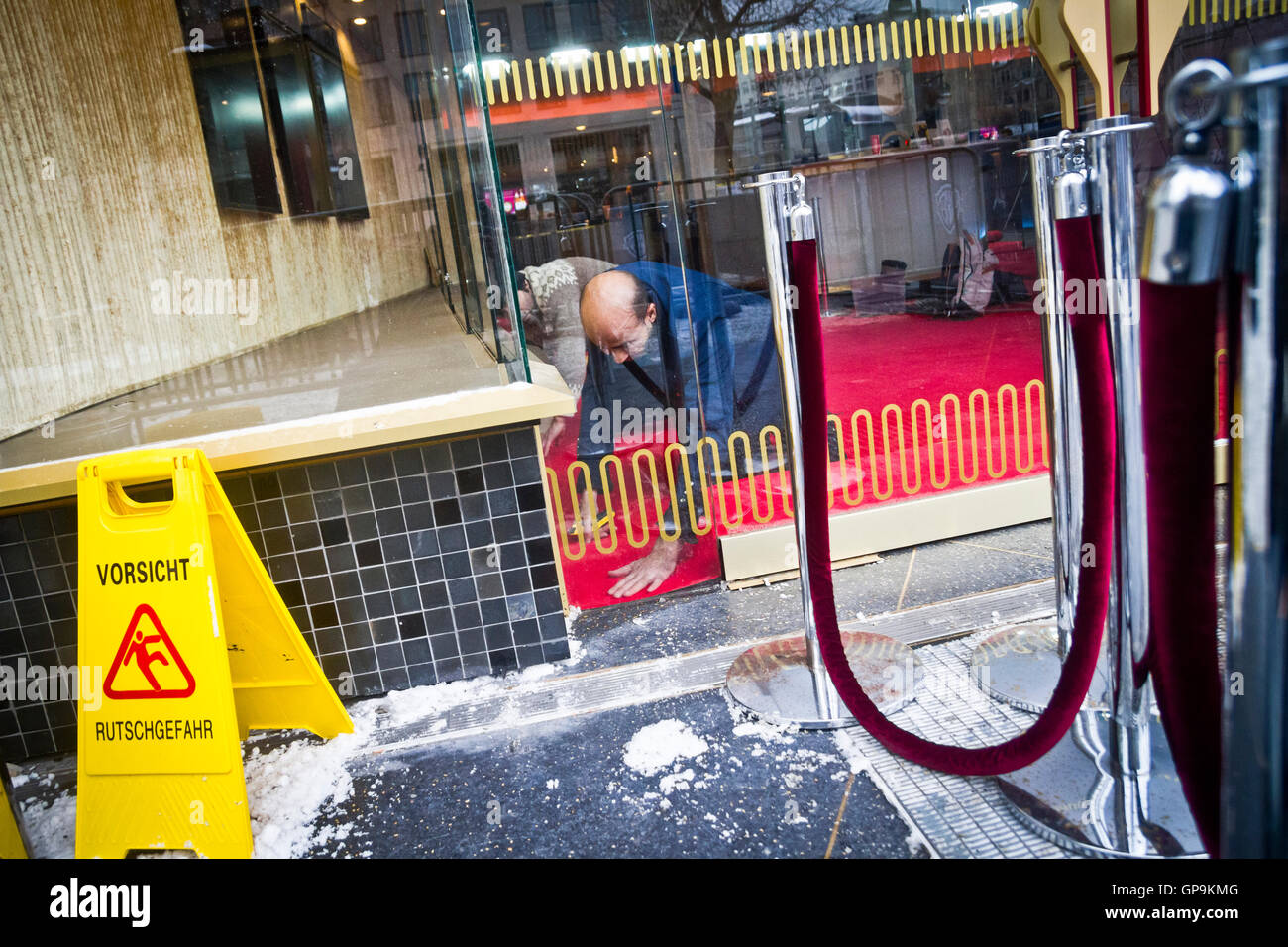 Gli uomini di mettere il tappeto rosso al posto presso lo Zoo Palast cinema a Berlino, Germania. Foto Stock