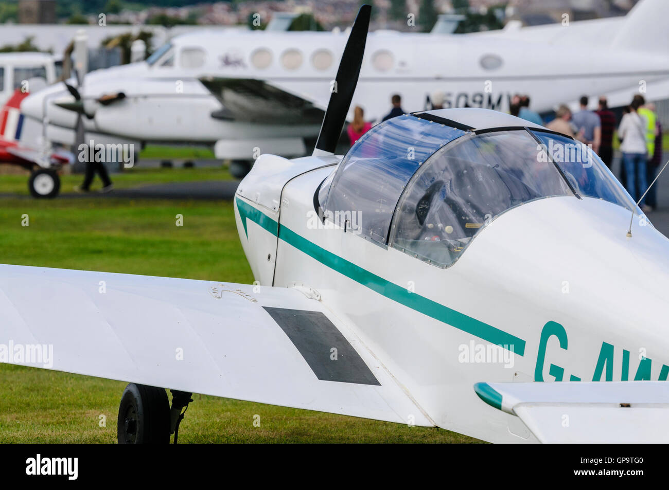 La gente in coda fino a ottenere su un 1981 Faggio B200 re aria twin propulsori turboelica aereo passeggeri in un aeroporto accanto a un FURGONI RV-8 Foto Stock