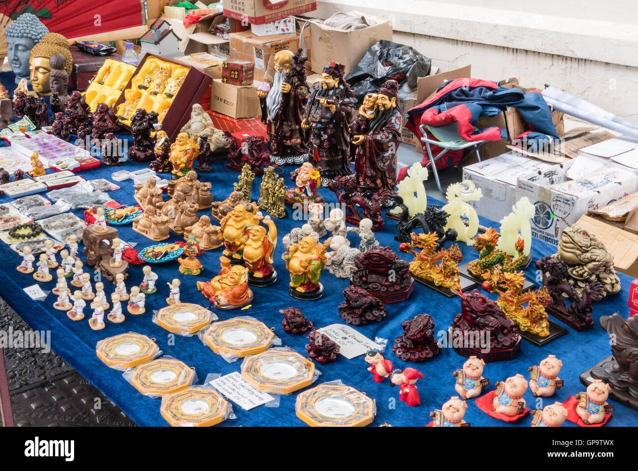 Statue cinesi e delle merci per la vendita su un mercato in stallo. Foto Stock