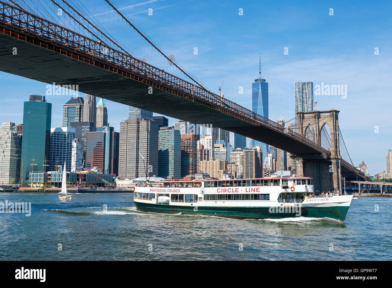 NEW YORK CITY - Agosto 27, 2016: Una Circle Line sightseeing barca porta i turisti sotto il ponte di Brooklyn per una gita. Foto Stock
