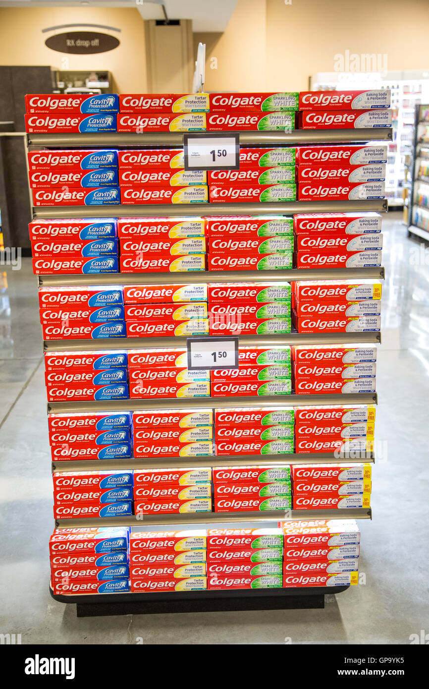 Pile di Dentifricio Colgate scatole in esposizione su scaffali presso un negozio di alimentari Foto Stock