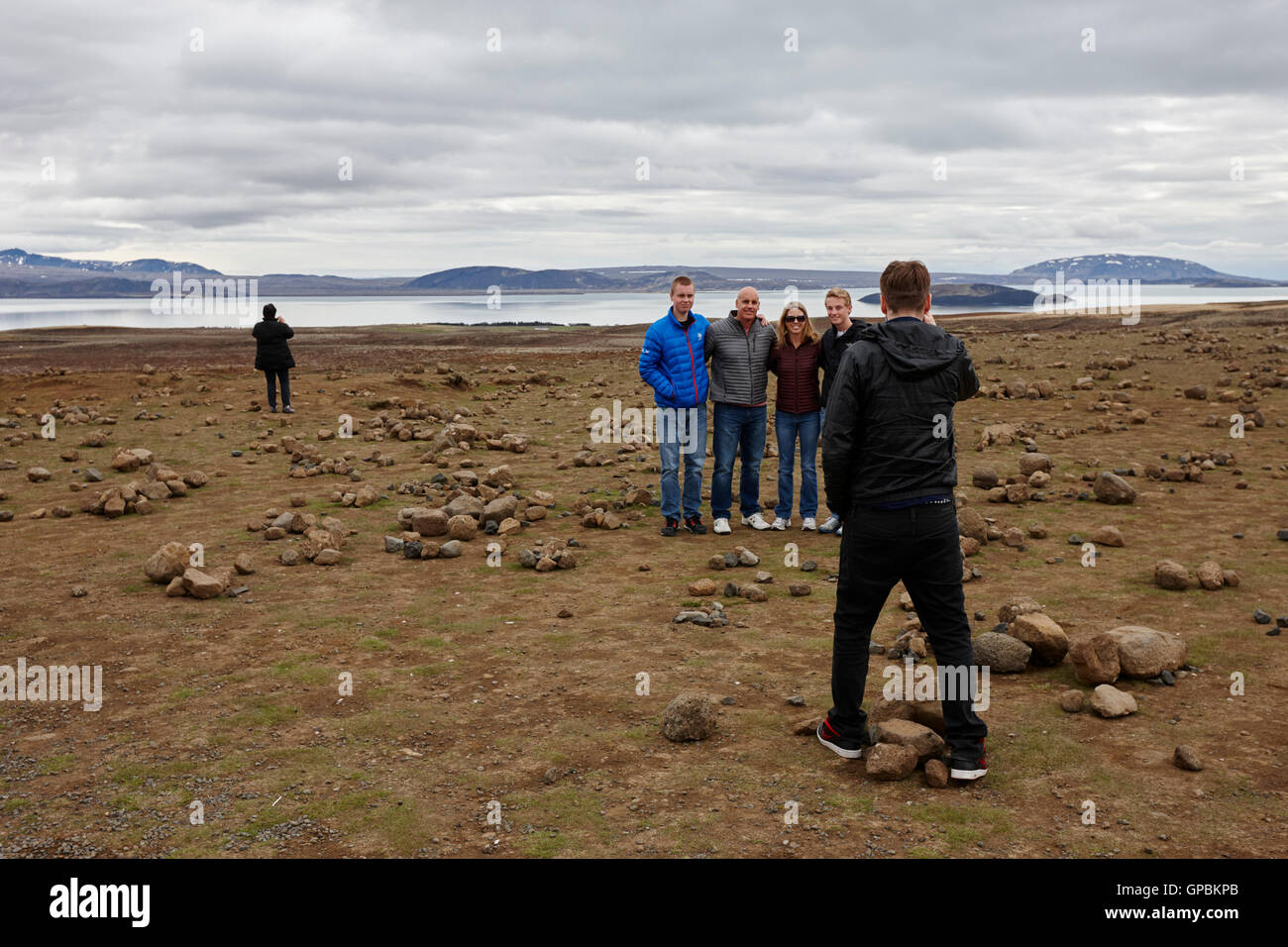 I turisti scattare foto al campo delle pietre dove i turisti mucchio di pietre che si affaccia sul lago thingvellir Islanda Foto Stock
