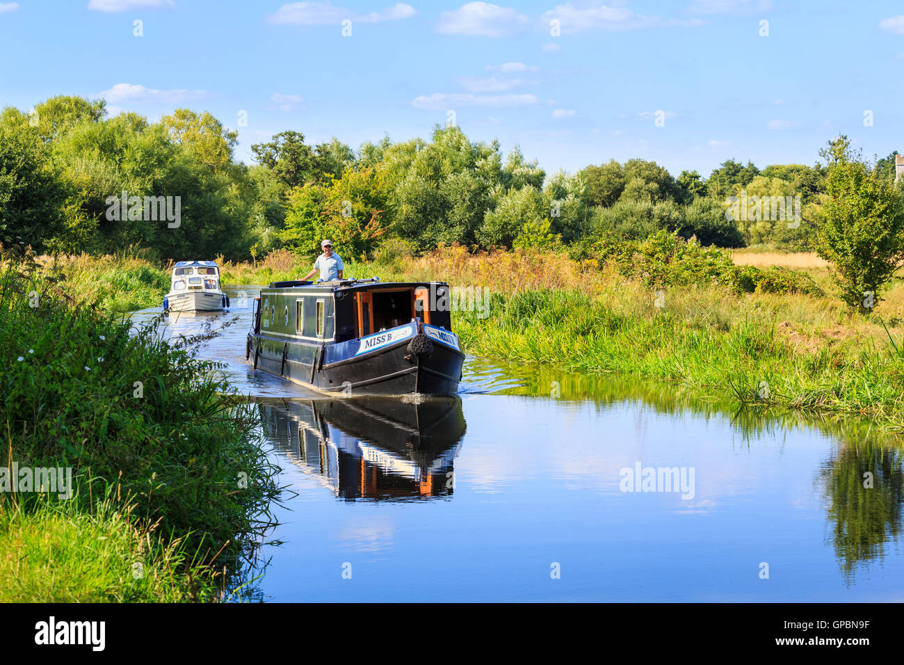 Narrowboat barca a motore e piacevole crociera sul Wey Navigation vicino a inviare, Surrey in una giornata di sole con cielo blu in estate Foto Stock