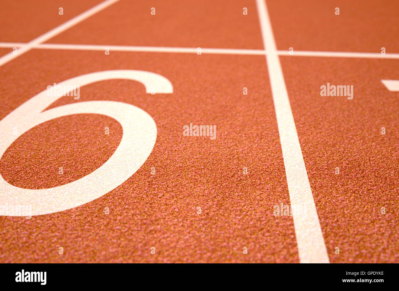 Un 3D rendering di una sezione della linea di partenza di un'arancia pista atletica lane in ore diurne Foto Stock