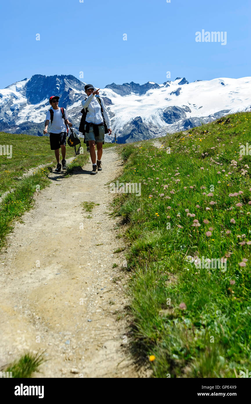 La madre e il suo sole trekking nelle Alpi francesi durante il periodo estivo con un ghiacciaio in background, alpi, Francia, Europa Foto Stock