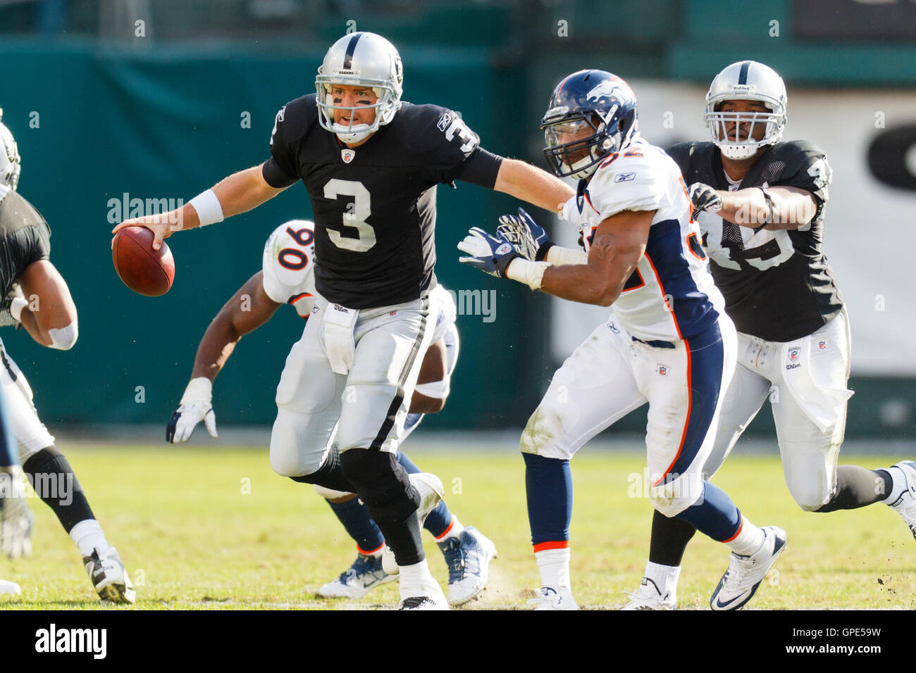 Novembre 6, 2011; Oakland, CA, Stati Uniti d'America; Oakland Raiders quarterback Carson Palmer (3) viene pressurizzato fuori della tasca da Denver Broncos difensivo fine Jason Hunter (52) durante il secondo trimestre a O.co Coliseum. Foto Stock