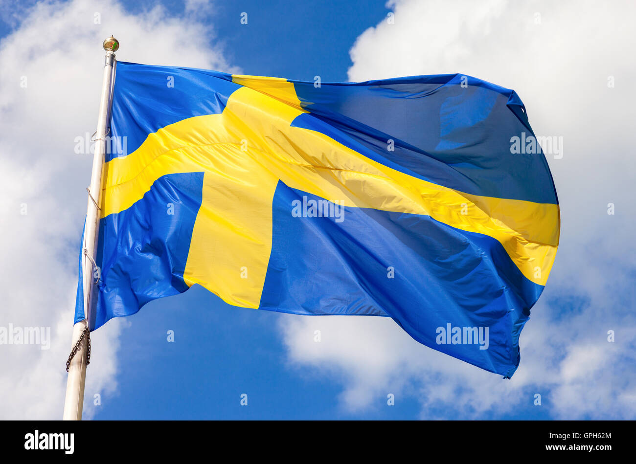 Bandiera svedese blu con croce gialla sventolare nel vento contro un cielo  azzurro sfondo con il cloud Foto stock - Alamy