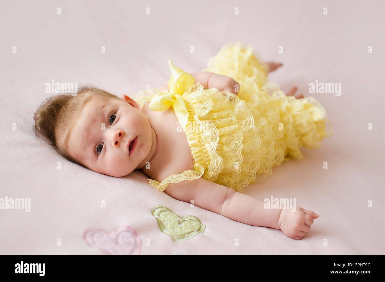 Adorabili due mesi bambina sdraiata su una coperta rosa Foto Stock